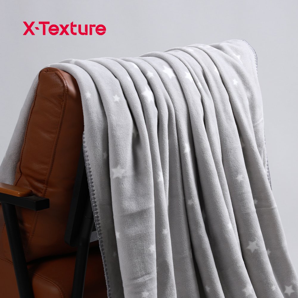 Grey star print soft and warm double side fleece fabric draped over a chair.