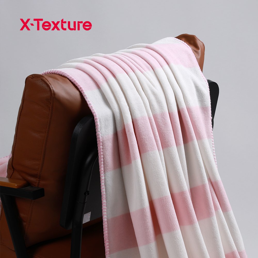 Pink plaid print soft and warm double side fleece fabric draped over a chair.